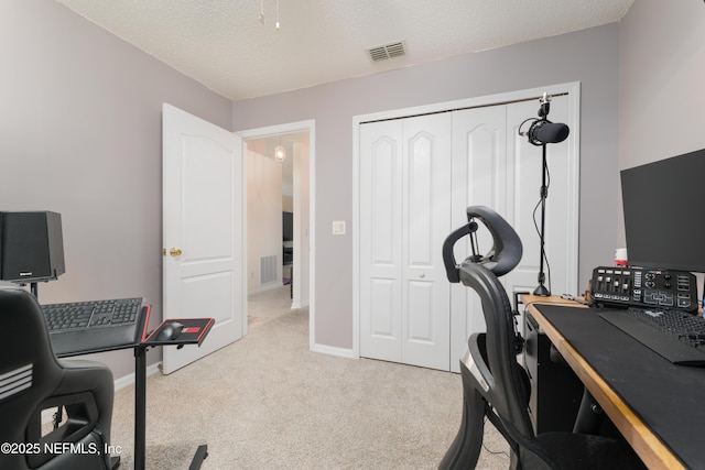 home office with light colored carpet and a textured ceiling