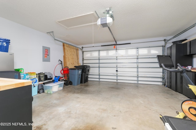 garage with a garage door opener and electric panel