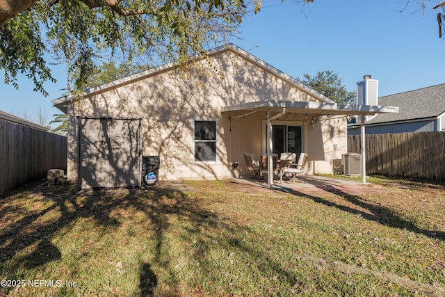 back of property with a patio area, central AC, and a yard