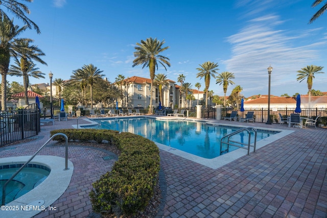 view of swimming pool with a patio area and a community hot tub