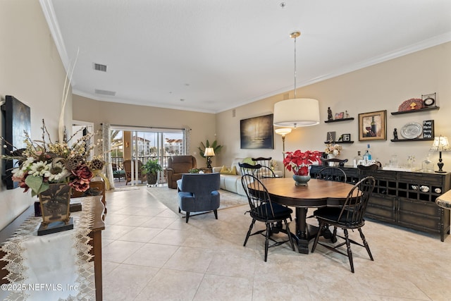 dining area featuring ornamental molding and light tile patterned flooring