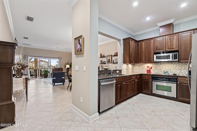 kitchen featuring dark stone countertops, light tile patterned floors, ornamental molding, appliances with stainless steel finishes, and dark brown cabinetry