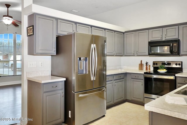 kitchen featuring gray cabinets, ceiling fan, stainless steel appliances, and vaulted ceiling