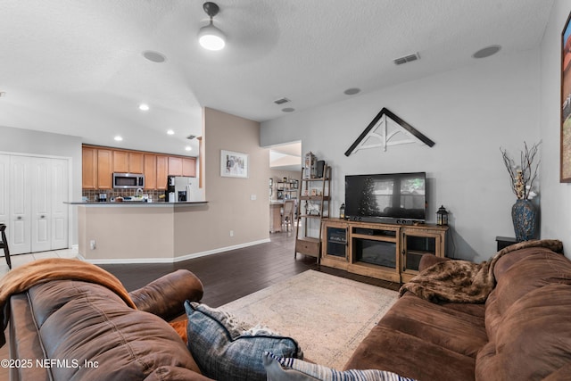 living room with hardwood / wood-style flooring, ceiling fan, and a textured ceiling