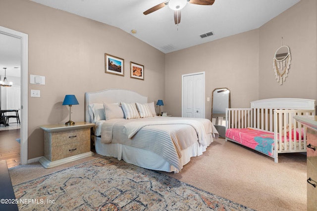 bedroom featuring ceiling fan with notable chandelier, carpet flooring, vaulted ceiling, and a closet