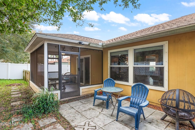 view of patio / terrace with a sunroom and an outdoor fire pit