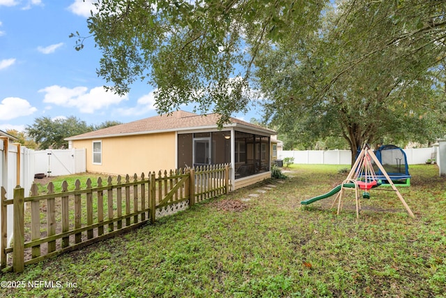 view of yard with a sunroom and a trampoline