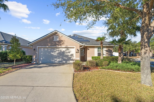 view of front of home with a garage, a front lawn, and solar panels