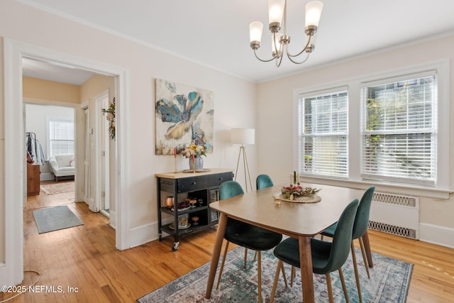 dining space with a notable chandelier, wood-type flooring, crown molding, and radiator