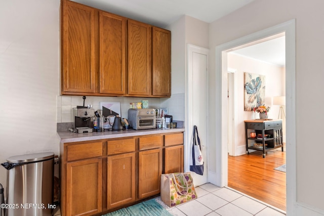 kitchen featuring light tile patterned floors and backsplash