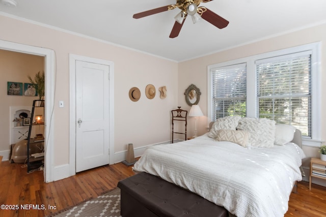 bedroom featuring ceiling fan, hardwood / wood-style floors, and crown molding