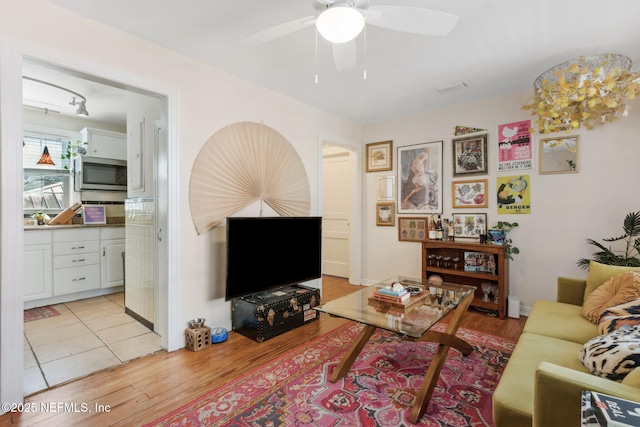 living room featuring light hardwood / wood-style flooring and ceiling fan