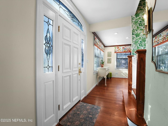 foyer entrance with dark wood-type flooring and crown molding