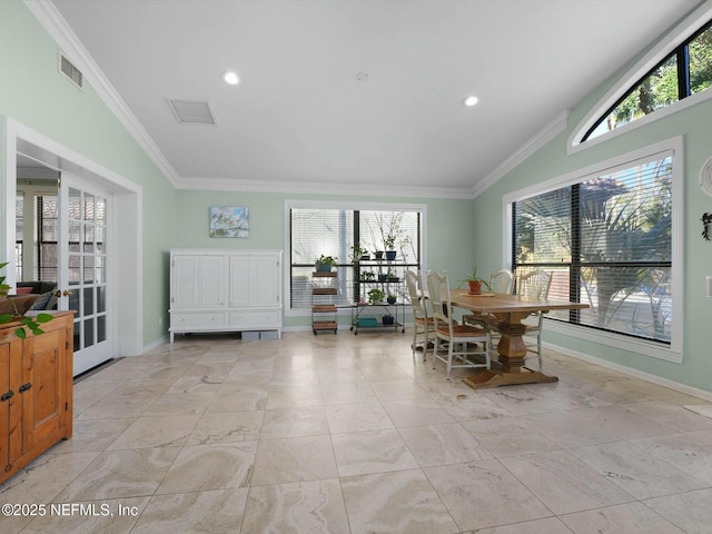 dining space with crown molding, vaulted ceiling, and plenty of natural light