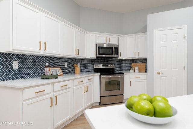 kitchen featuring tasteful backsplash, white cabinetry, and stainless steel appliances