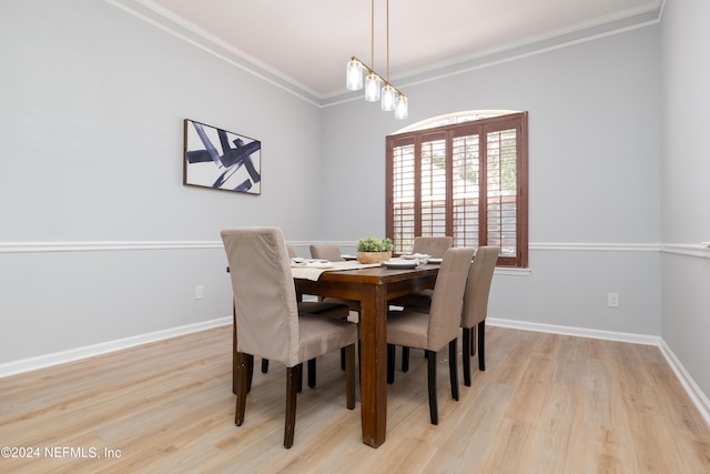 dining space with light hardwood / wood-style flooring, a chandelier, and ornamental molding