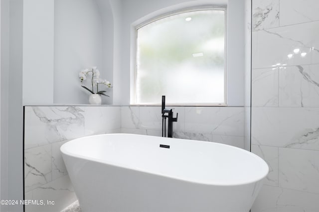 bathroom featuring a tub and tile walls