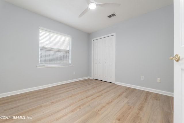 unfurnished bedroom with ceiling fan, a closet, and light hardwood / wood-style floors