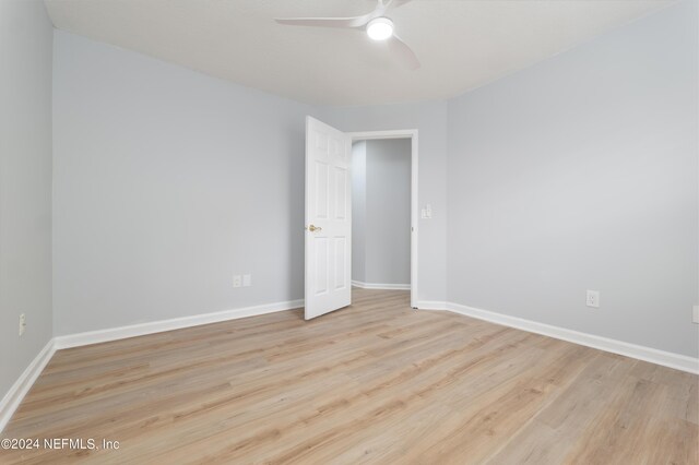 empty room with ceiling fan and light hardwood / wood-style floors