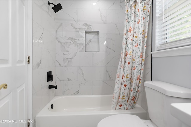 bathroom with toilet and shower / bath combo with shower curtain