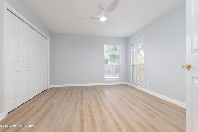 unfurnished bedroom featuring light wood-type flooring, a closet, and ceiling fan