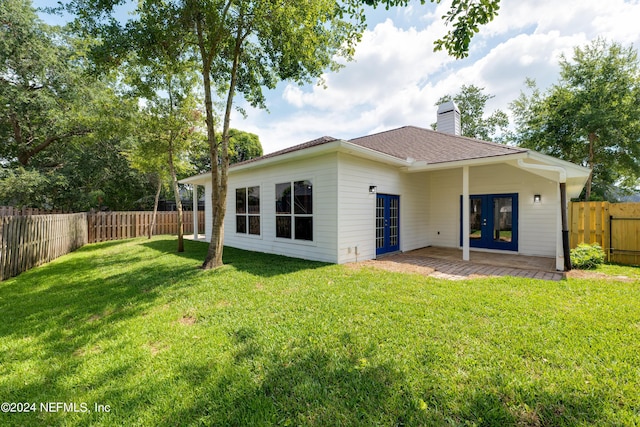 rear view of house featuring a yard, a patio, and french doors