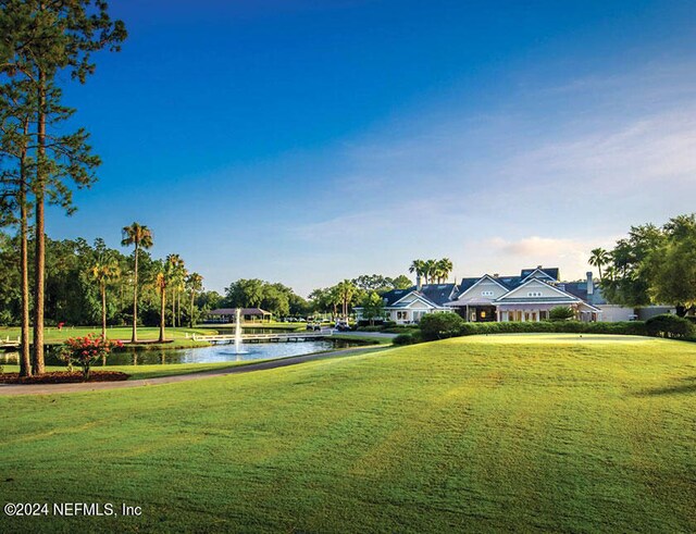 view of home's community with a yard and a water view