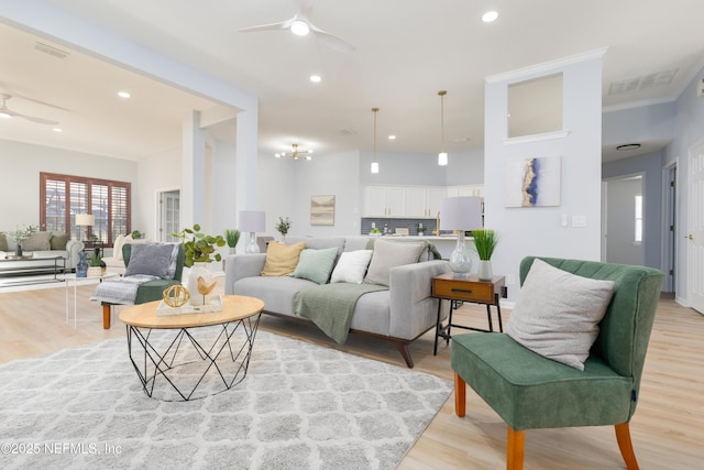 living room with ceiling fan, light hardwood / wood-style floors, and ornamental molding