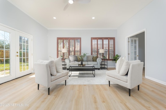 living room with ceiling fan, crown molding, light hardwood / wood-style flooring, and french doors