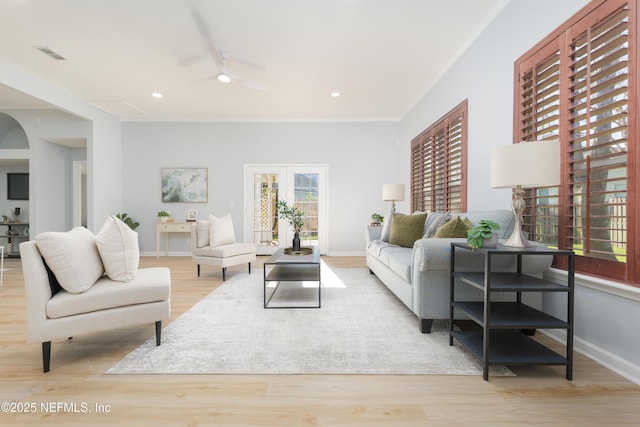 living room featuring ceiling fan, french doors, rail lighting, light hardwood / wood-style flooring, and ornamental molding