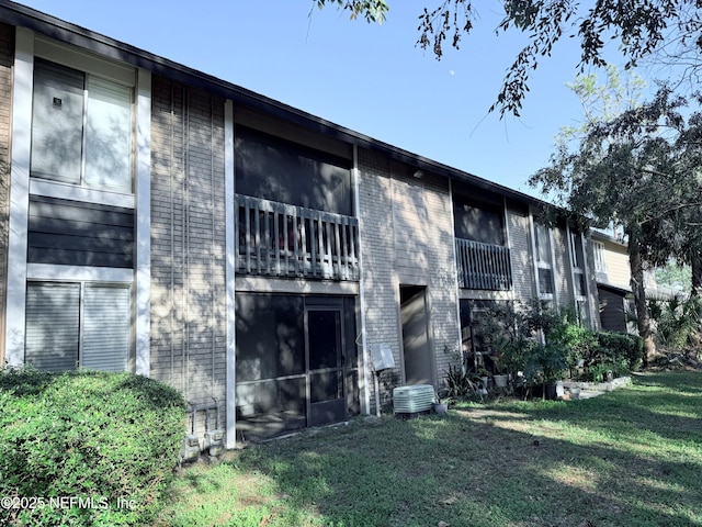 back of house with a yard, central AC unit, and a sunroom