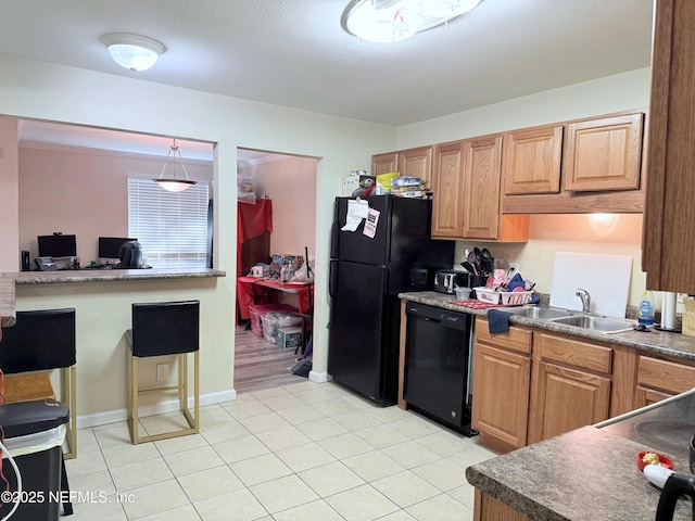 kitchen with pendant lighting, sink, light tile patterned floors, and black appliances