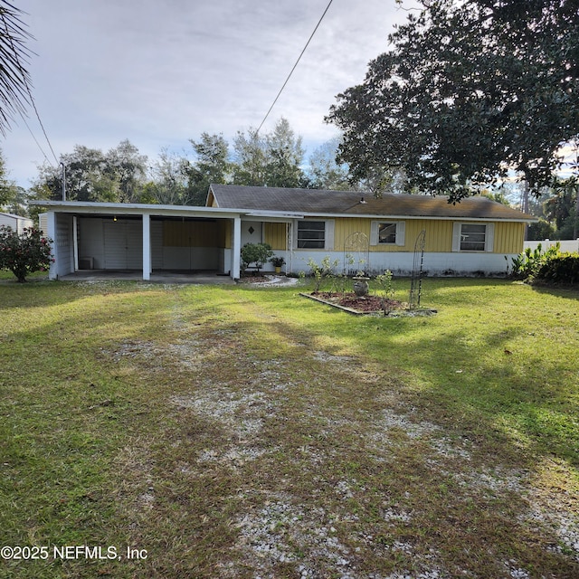 rear view of property featuring a lawn and a carport