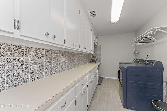 laundry area with washer and dryer and cabinets