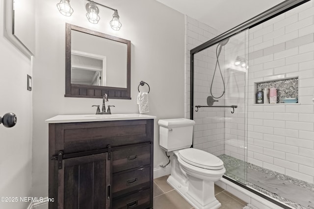 bathroom with tile patterned floors, vanity, toilet, and walk in shower