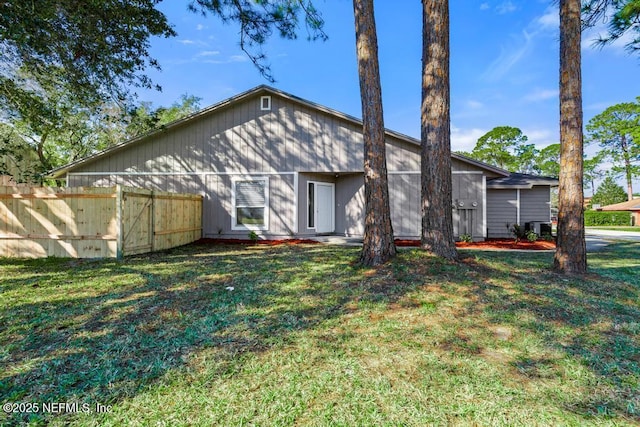 rear view of property with a lawn