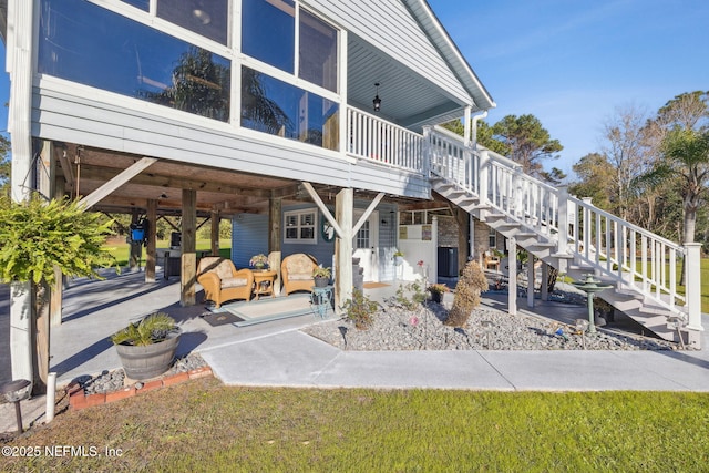 rear view of property featuring outdoor lounge area, a patio area, and a lawn