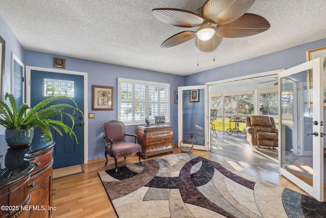 sitting room featuring a textured ceiling, light hardwood / wood-style floors, and ceiling fan