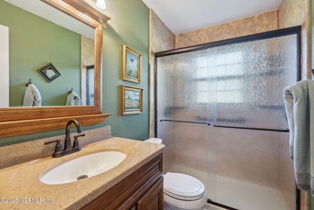 bathroom featuring vanity, toilet, and walk in shower