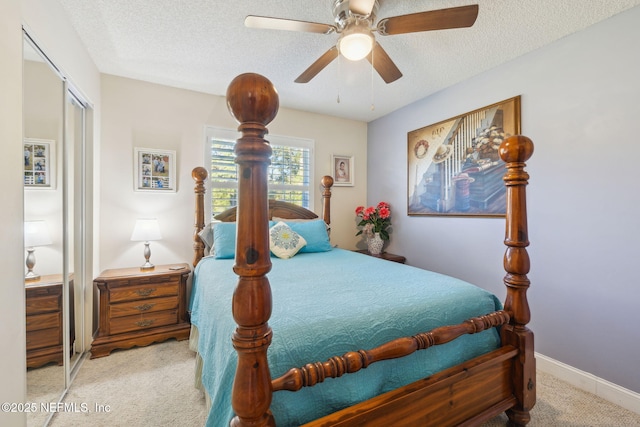 bedroom featuring light carpet, a textured ceiling, a closet, and ceiling fan