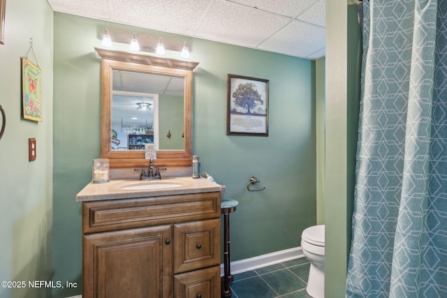 bathroom featuring a paneled ceiling, vanity, tile patterned floors, a shower with curtain, and toilet