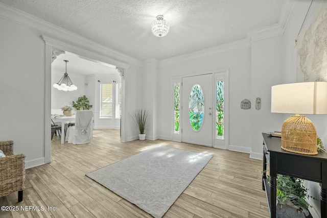 foyer featuring a textured ceiling, light hardwood / wood-style floors, and crown molding