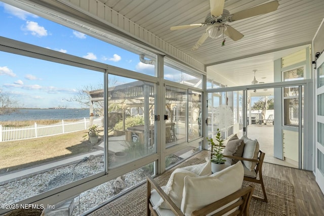 sunroom / solarium featuring a water view and ceiling fan