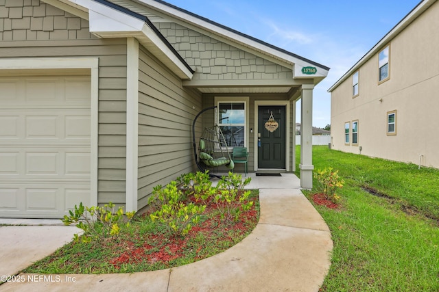 view of exterior entry featuring a lawn and a garage