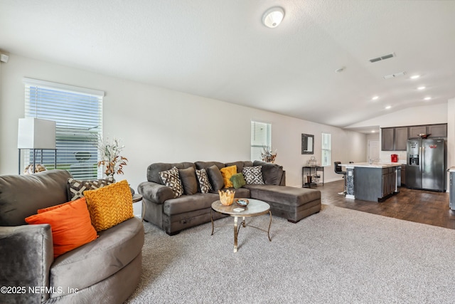 living room featuring dark carpet and lofted ceiling