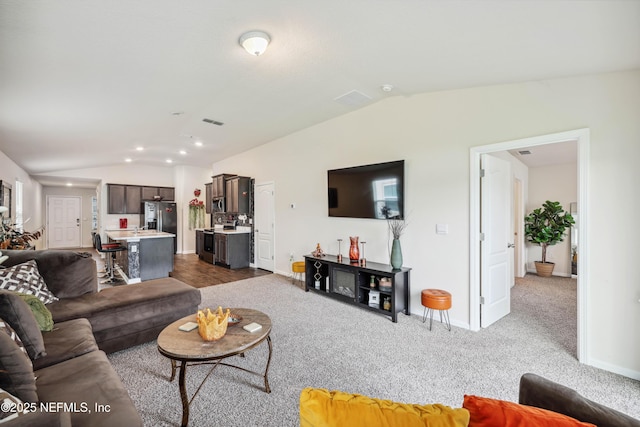 living room featuring dark colored carpet and vaulted ceiling