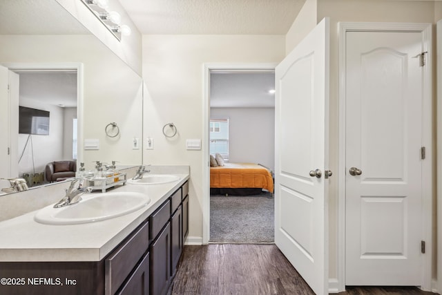 bathroom featuring hardwood / wood-style floors, vanity, and a textured ceiling