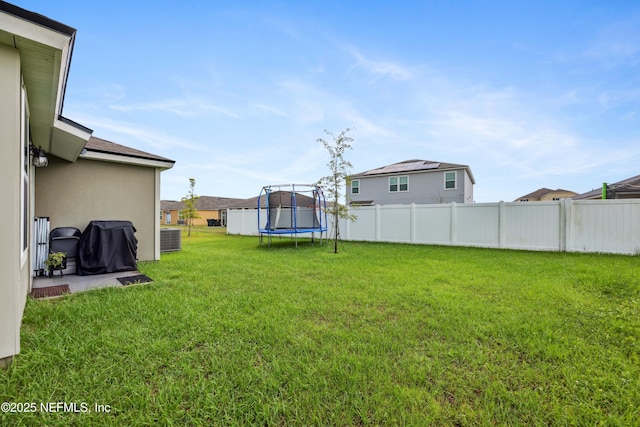 view of yard with a trampoline and cooling unit