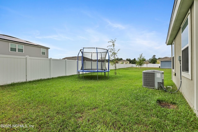 view of yard featuring cooling unit and a trampoline