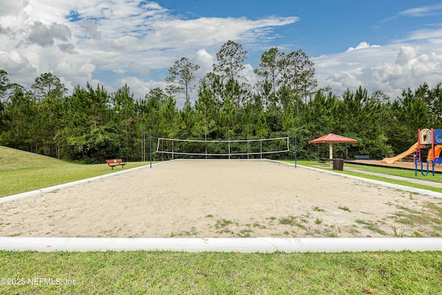 surrounding community featuring volleyball court, a playground, and a lawn